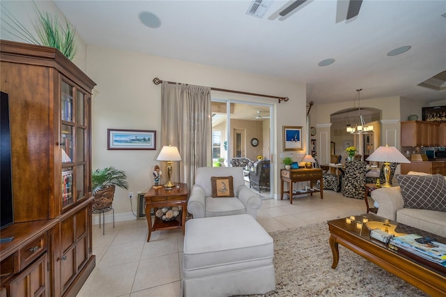 tiled living room featuring ceiling fan with notable chandelier