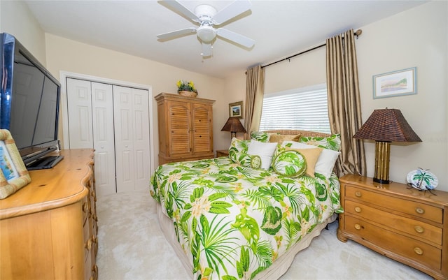 bedroom featuring ceiling fan, light colored carpet, and a closet