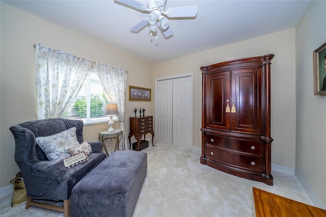 living area with ceiling fan and light colored carpet