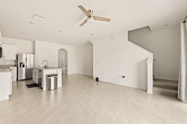 tiled living room with ceiling fan and sink