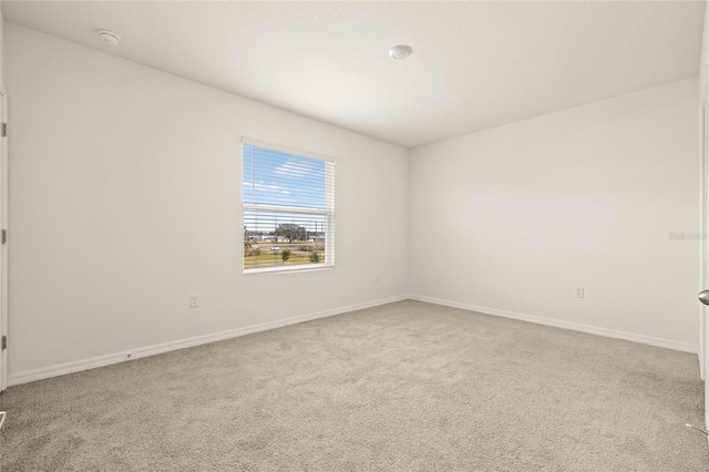 unfurnished room featuring light colored carpet