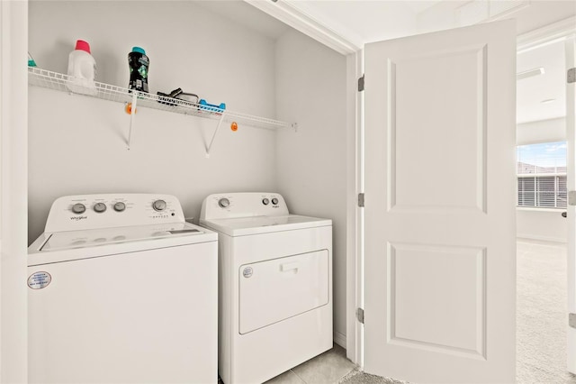 washroom with light tile patterned floors and washing machine and clothes dryer