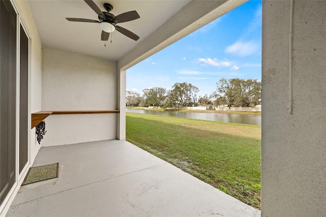 view of patio with ceiling fan and a water view