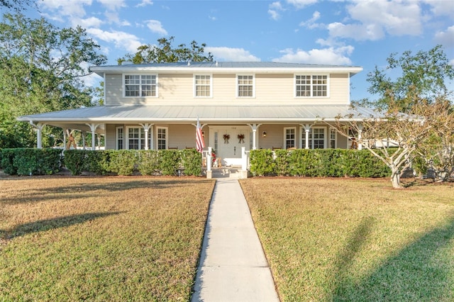 7312 7th Ave NW, Bradenton, FL 34209 - farmhouse featuring covered porch, metal roof, and a front yard