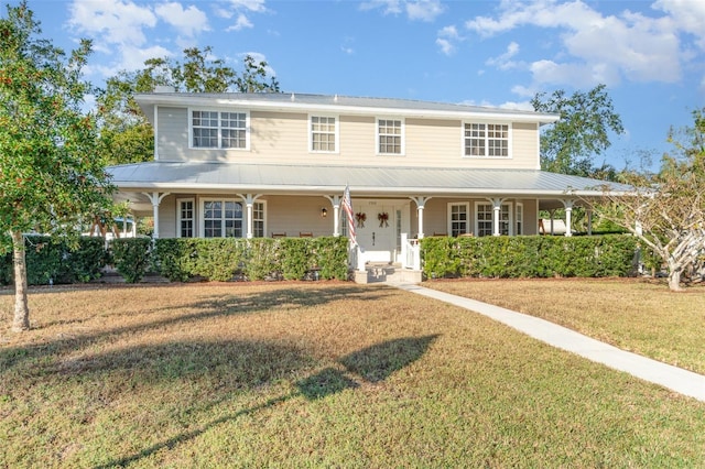 7312 7th Ave NW, Bradenton, FL 34209 - country-style home with covered porch, metal roof, and a front yard
