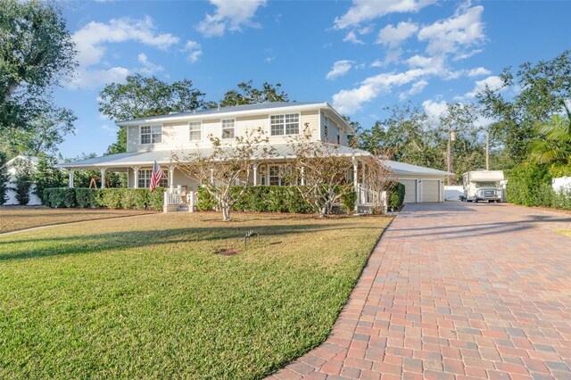 7312 7th Ave NW, Bradenton, FL 34209 - country-style home with covered porch, a front lawn, and decorative driveway