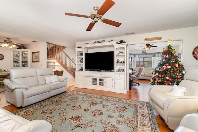 7312 7th Ave NW, Bradenton, FL 34209 - living area featuring a ceiling fan, stairway, and light wood-style flooring