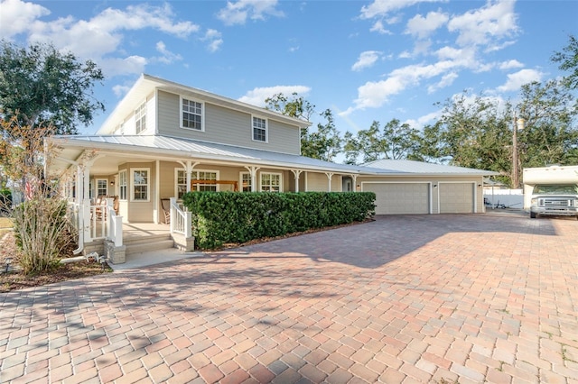 7312 7th Ave NW, Bradenton, FL 34209 - farmhouse-style home featuring covered porch, an attached garage, decorative driveway, and metal roof