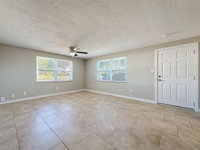 tiled empty room with a textured ceiling and ceiling fan