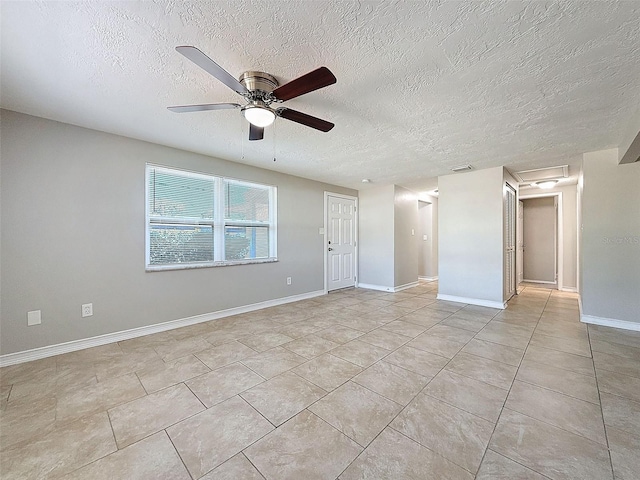 unfurnished room with a textured ceiling, ceiling fan, and light tile patterned floors