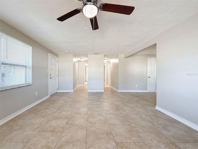 tiled empty room featuring ceiling fan and a textured ceiling