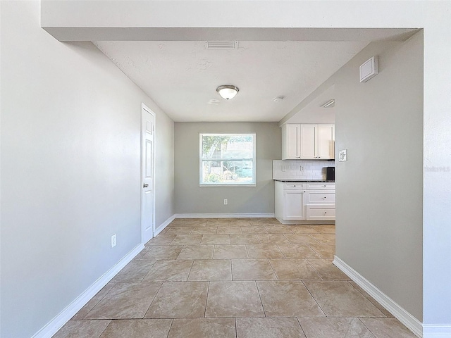 kitchen featuring backsplash and white cabinetry