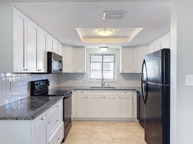 kitchen with sink, white cabinets, a tray ceiling, and black appliances