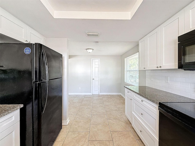 kitchen featuring black appliances, dark stone countertops, and white cabinetry