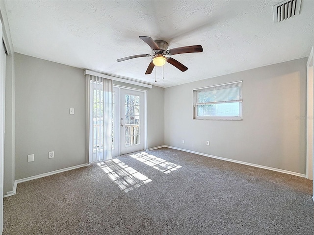 carpeted empty room with ceiling fan and a textured ceiling