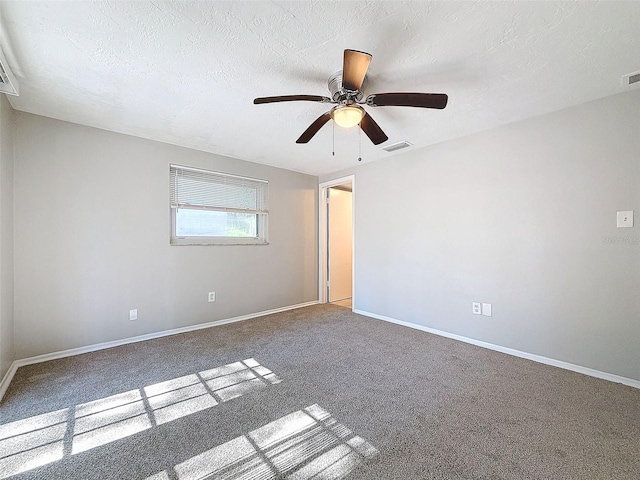 carpeted empty room featuring a textured ceiling and ceiling fan