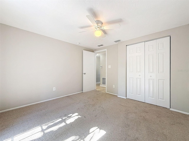 unfurnished bedroom featuring light carpet, ceiling fan, and a closet