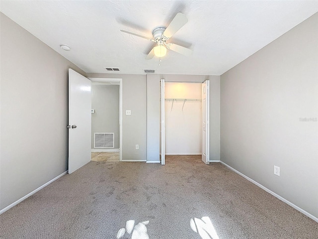 unfurnished bedroom featuring ceiling fan, a closet, and light colored carpet