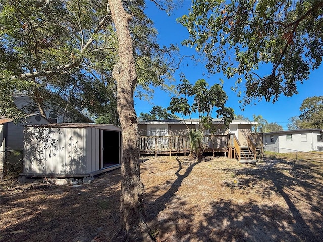 view of yard with a deck and a storage shed