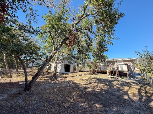 view of yard with a wooden deck and a storage shed