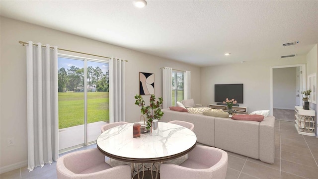 dining space featuring a textured ceiling and light tile patterned floors