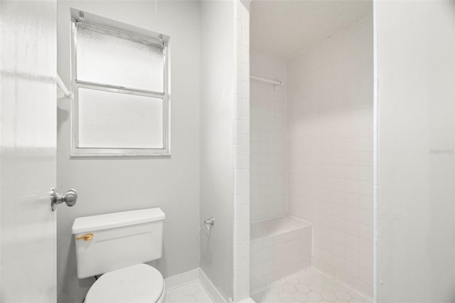 bathroom with tiled shower and toilet