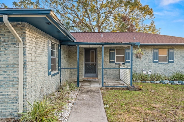 doorway to property featuring a yard and covered porch