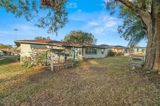 rear view of property featuring a lawn