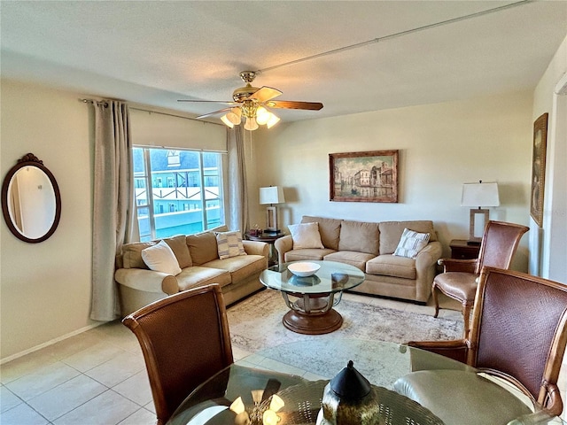 living room with ceiling fan, a textured ceiling, and light tile patterned floors