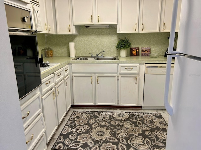 kitchen with decorative backsplash, sink, white appliances, white cabinetry, and light tile patterned floors