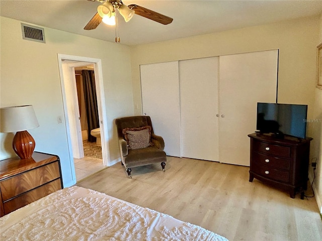 bedroom with ceiling fan, ensuite bath, a closet, and light hardwood / wood-style floors