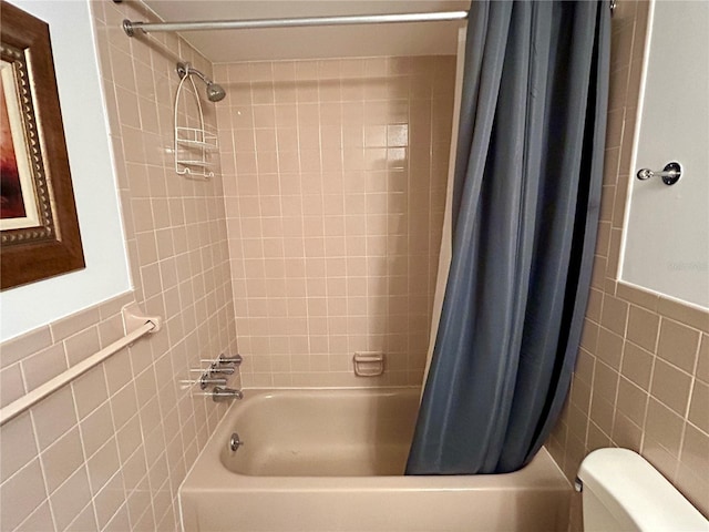 bathroom featuring tile walls, toilet, and shower / tub combo