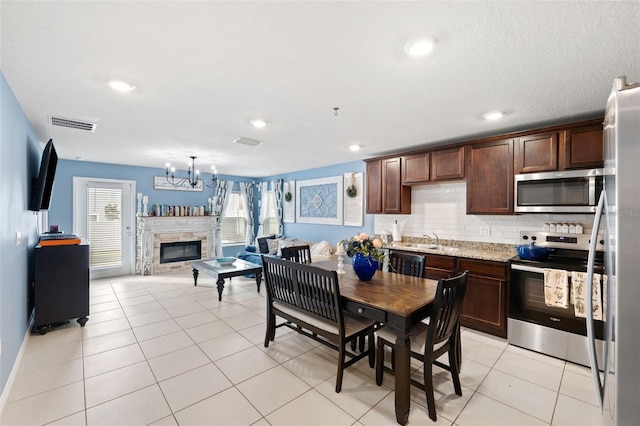 dining space with an inviting chandelier, light tile patterned floors, and sink