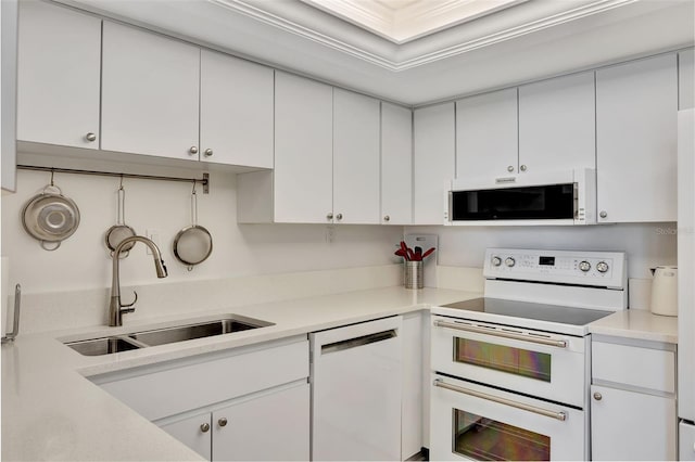 kitchen with white cabinets, white appliances, and light countertops