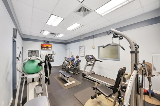 gym with baseboards, visible vents, and a drop ceiling