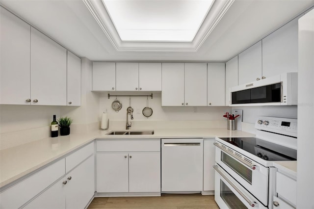 kitchen with light countertops, white appliances, and white cabinetry