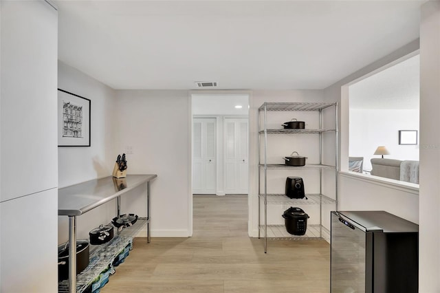 office featuring baseboards, beverage cooler, visible vents, and light wood-style floors