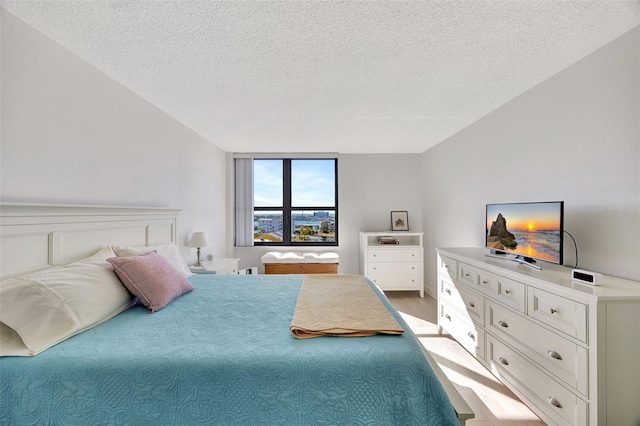 bedroom with a textured ceiling and wood finished floors