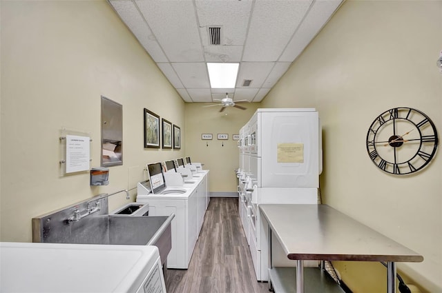 community laundry room featuring stacked washer and clothes dryer, washer and clothes dryer, visible vents, ceiling fan, and wood finished floors