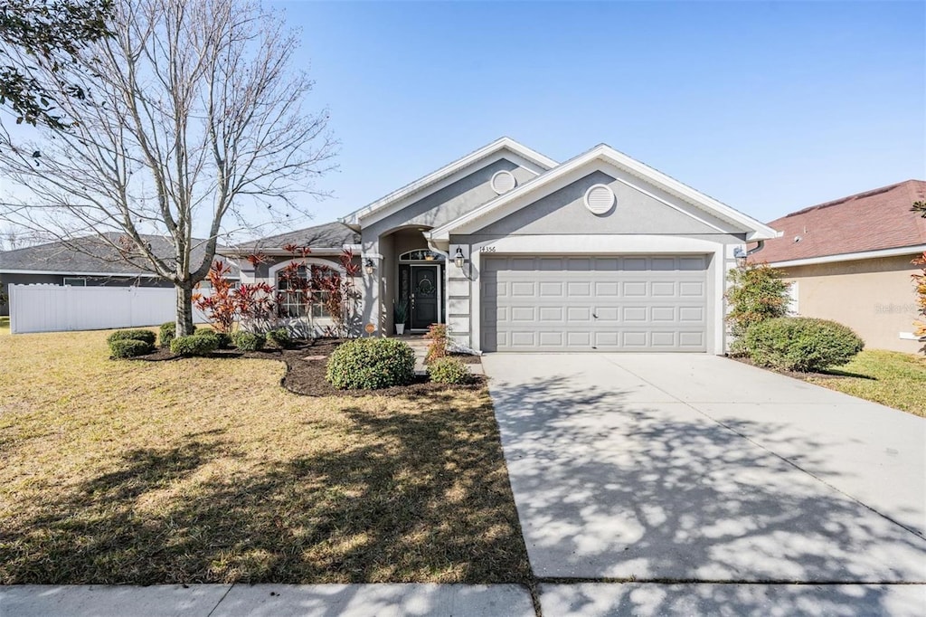 ranch-style home featuring a garage and a front lawn