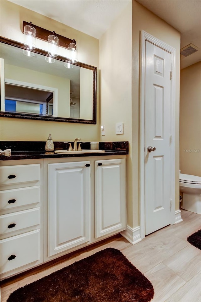 bathroom with vanity, hardwood / wood-style floors, and toilet