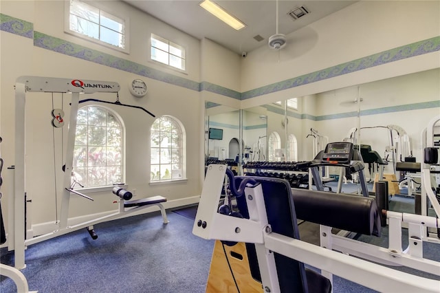 gym with a towering ceiling and ceiling fan