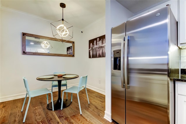 dining space with crown molding and light wood-type flooring