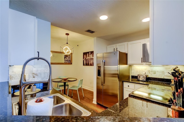 kitchen featuring sink, white cabinetry, stainless steel fridge with ice dispenser, hanging light fixtures, and dark hardwood / wood-style floors