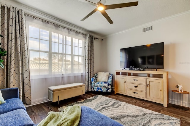 living room featuring dark wood-type flooring, a healthy amount of sunlight, and ornamental molding