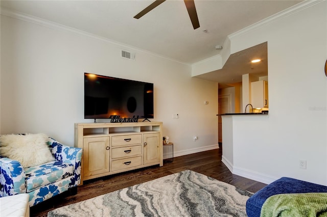 living room with crown molding, dark wood-type flooring, and ceiling fan