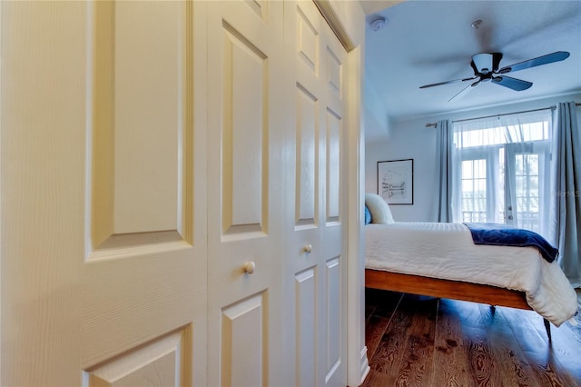 bedroom with crown molding, dark hardwood / wood-style floors, and ceiling fan