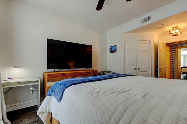 bedroom featuring ceiling fan, dark hardwood / wood-style floors, and a closet