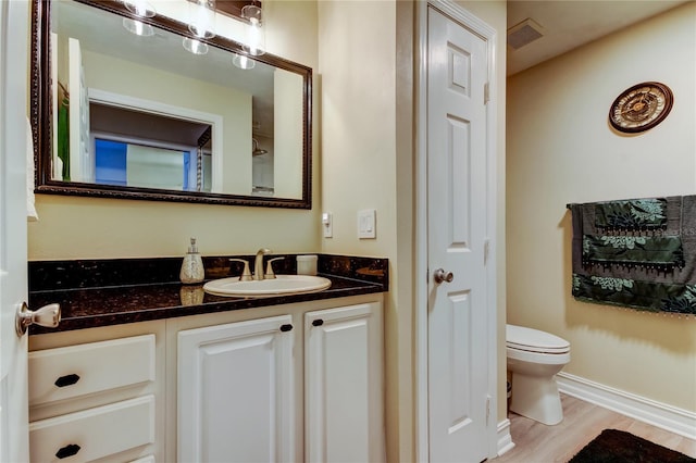 bathroom featuring hardwood / wood-style flooring, vanity, and toilet