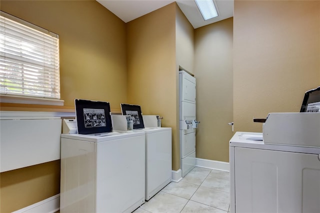 laundry room featuring separate washer and dryer and light tile patterned floors